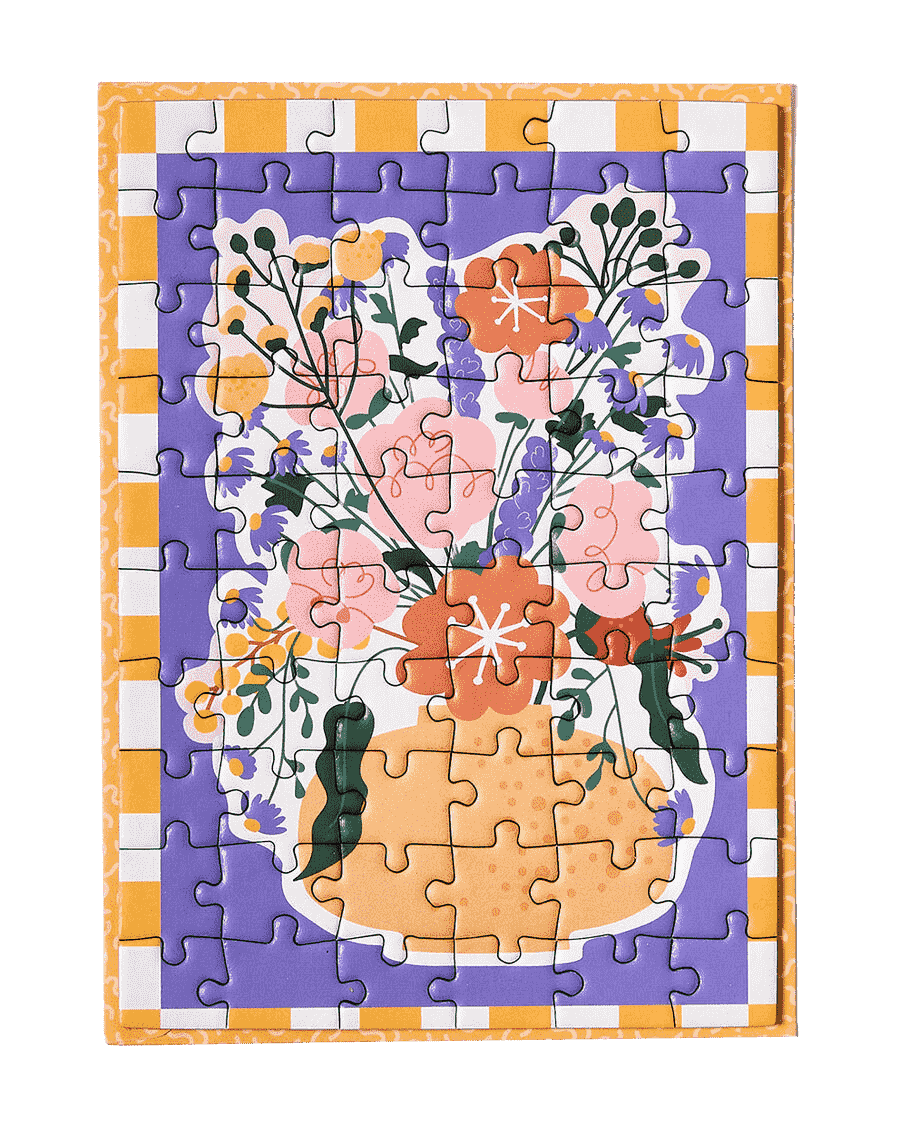 A greeting card puzzle with a yellow and white boarder, a purple background and a beautiful vase with a selection of delicate and intricate flowers in orange, peach, forest green and yellow. 