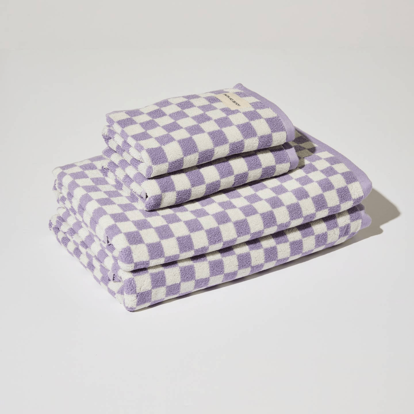 A small stack of matching white and lilac towels and hand towels. 