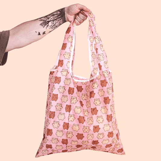 Super cute, Baby Bear Reusable Tote Bag by Fox and Cactus. This bag has a pink background with alternating light and dark tiny teddies across the front. 