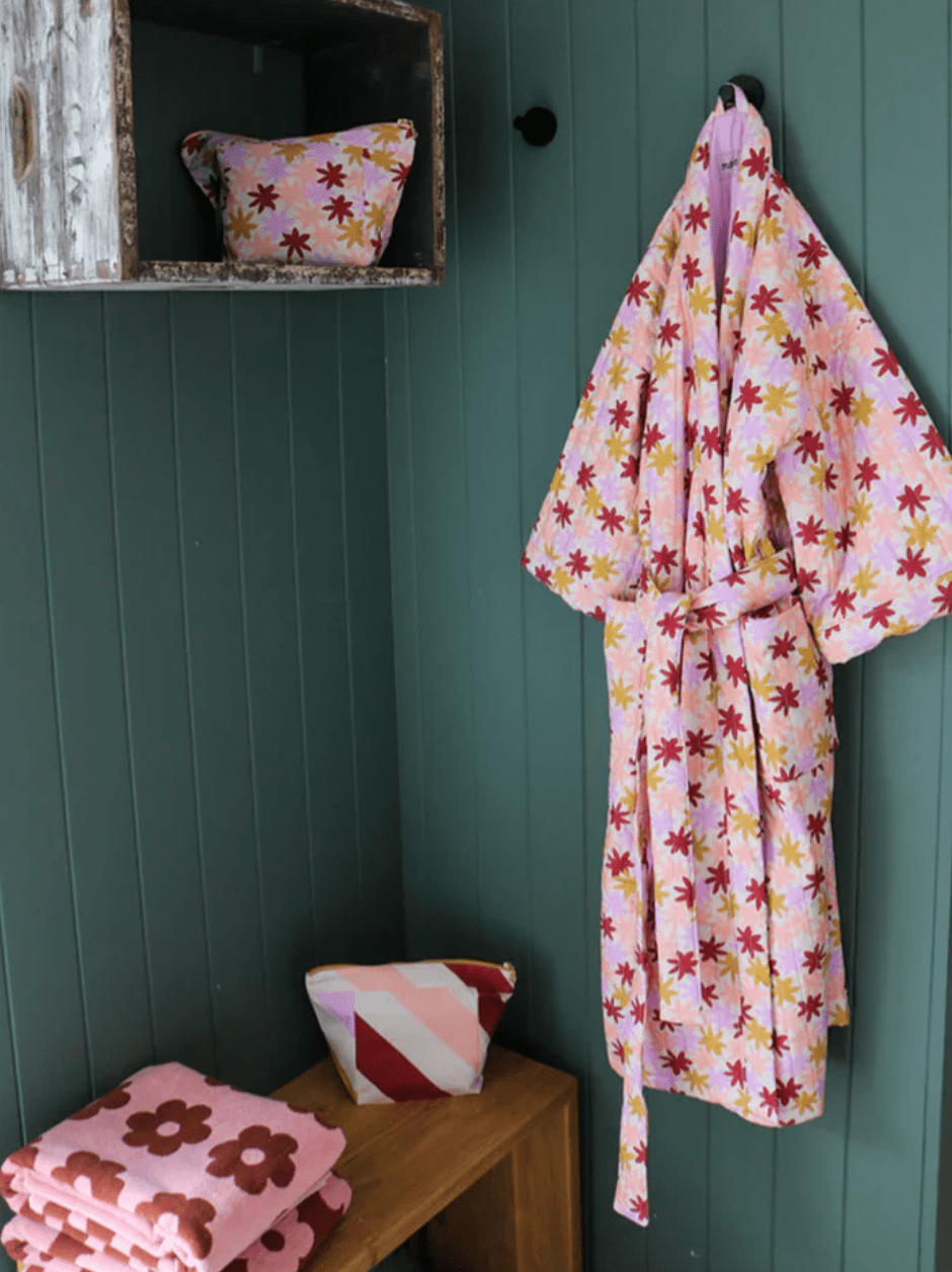 A mint green coloured room with the Peach robe hanging in the right hand corner. 