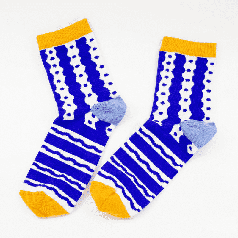 Shuh Lee Socks: Blue and white with a squiggle line design across the pattern with yellow splashes of colour at the toes and tops of each sock. 