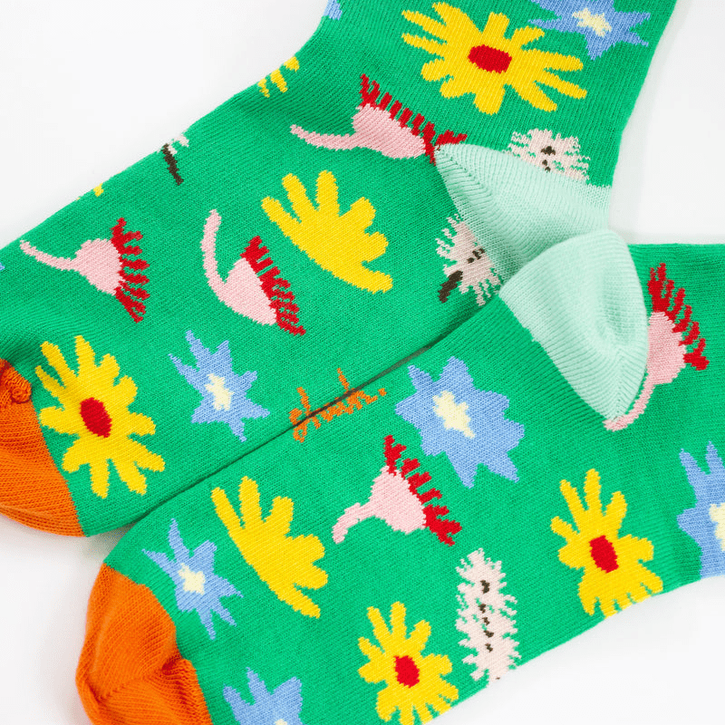 Meadow Socks: A gorgeous homage to nature, these socks have a bright green backdrop with scattered Australian florals across the print with orange accents on the top and toes of the socks. 