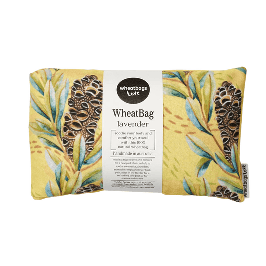 A Wheatbag Love wheat bag featuring a yellow backdrop with Leaves and banksia pods across the print. 